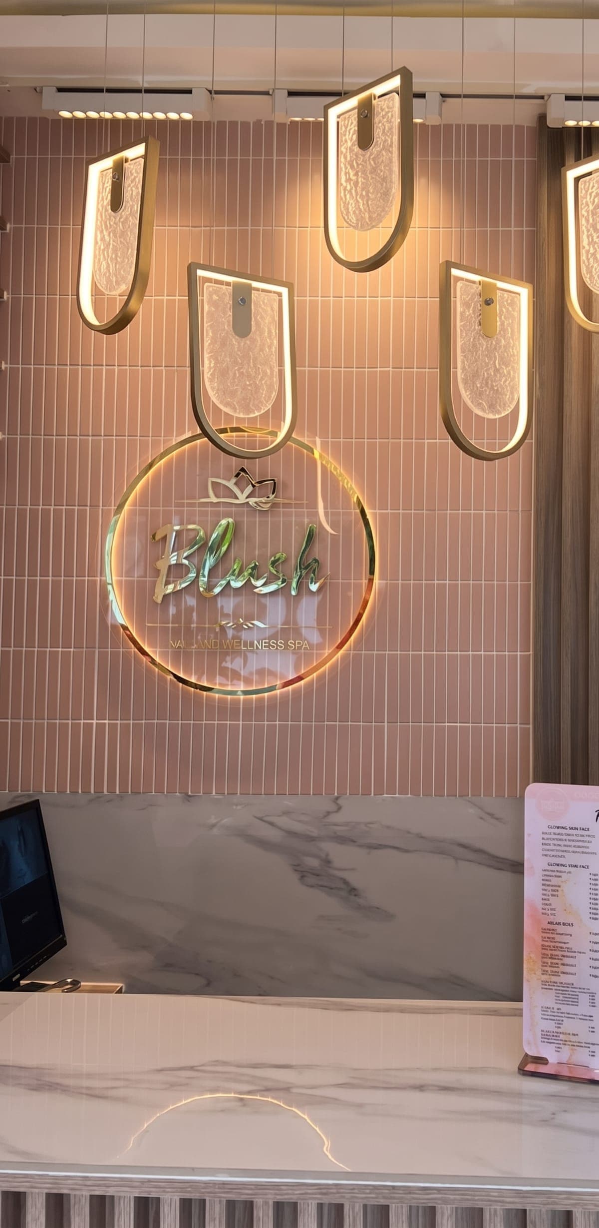The Blush reception wall with its glowing gold sign and pendant lights